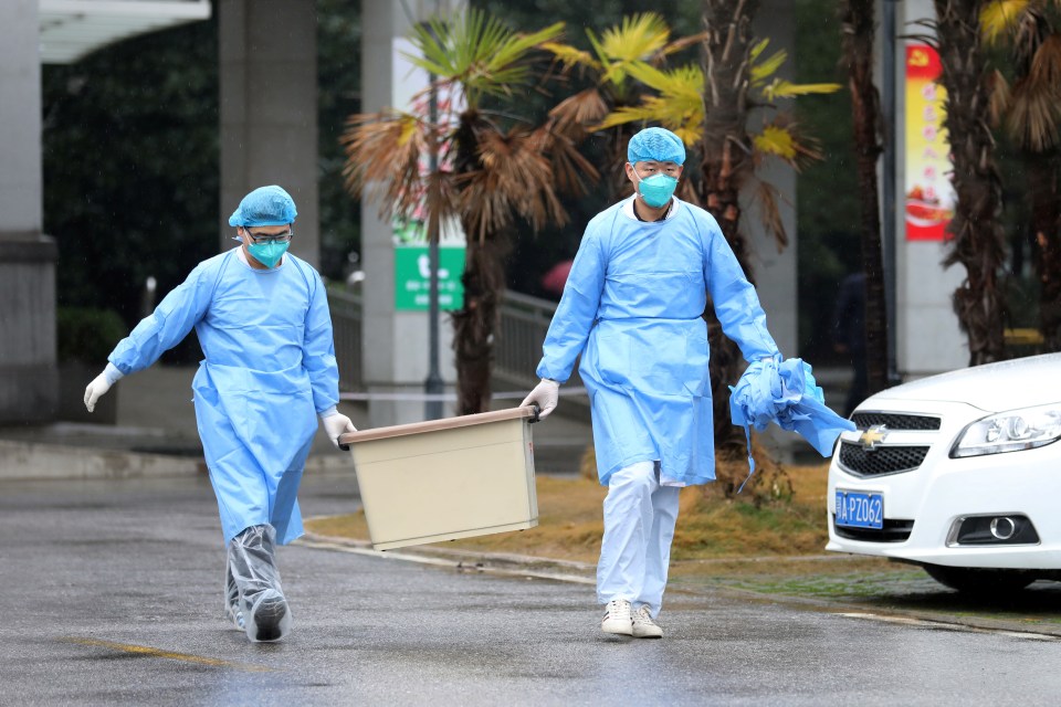 Medical staff carry a box as they walk at the Jinyintan hospital, where patients with pneumonia caused by coronavirus are being treated in China