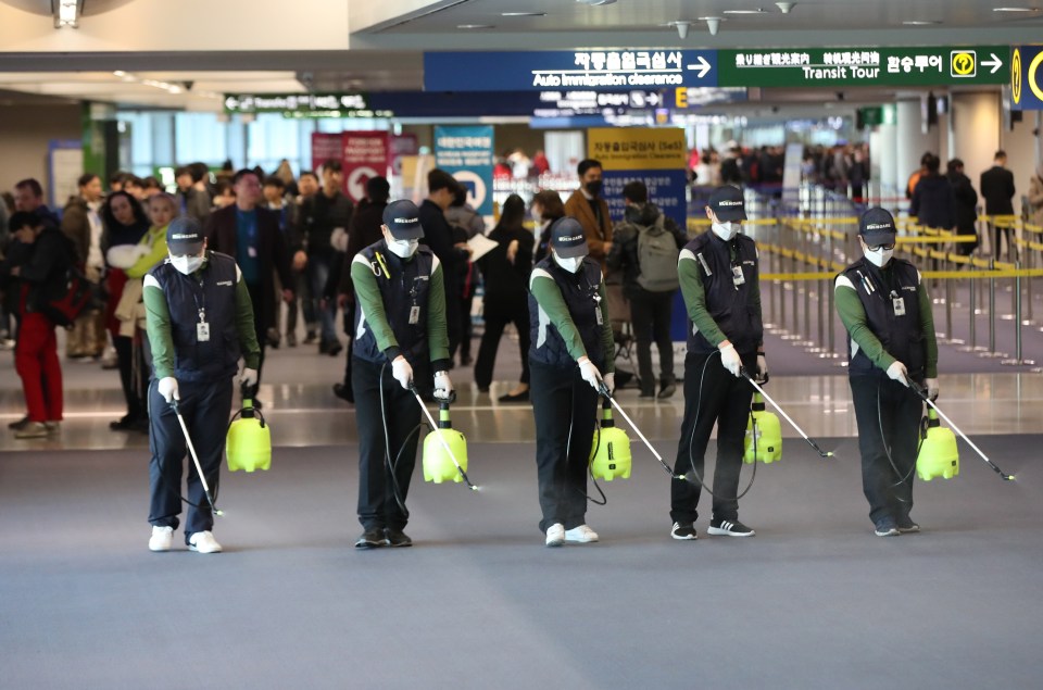 Quarantine workers are today spraying disinfectant at Incheon International Airport, South Korea, to prevent the advance of coronavirus now spreading in China