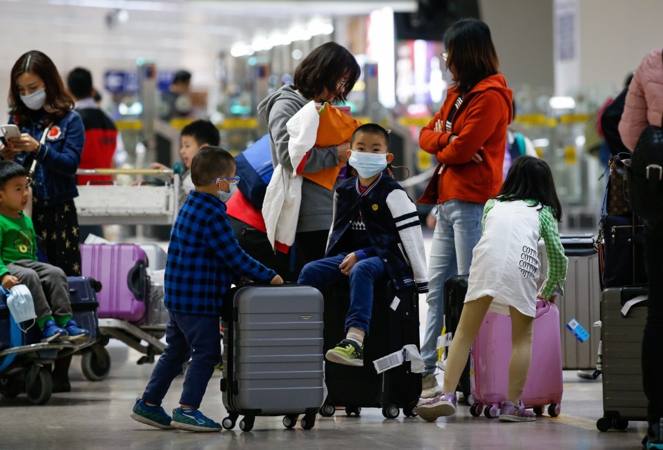  A boy wearing a face mask, who arrived from Guangzhou, China sits on top of a luggage at the Ninoy Aquino International Airport in Manila, Philippines