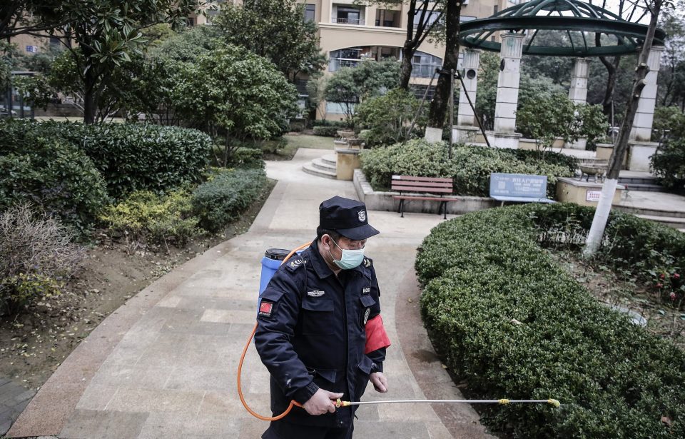  A man is using alcohol to disinfect a community in Wuhan after the city has been placed on lockdown