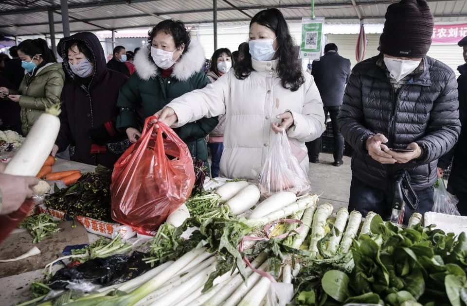  A Wuhan resident wears a mask while buying vegetables