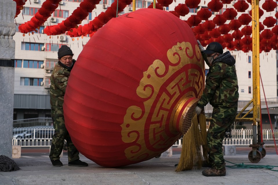 Workers dismantle decorations as the Chinese government scraps Lunar New Year celebrations