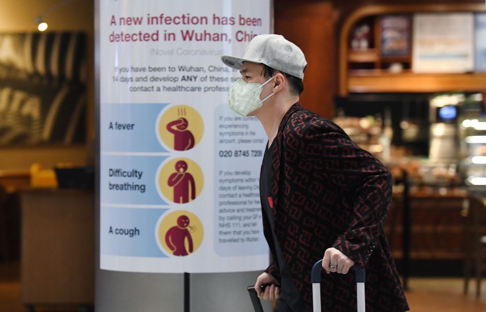  Coronavirus UK - A man wearing a face mask arrives at Heathrow Airport in London on Friday