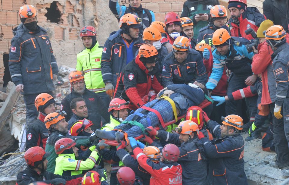  Rescue workers carry a survivor from a collapsed residential building