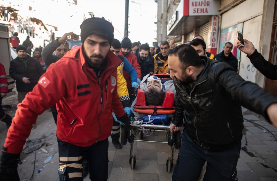  Rescue workers carry a survivor at the site of a collapsed building 17 hours on form the quake