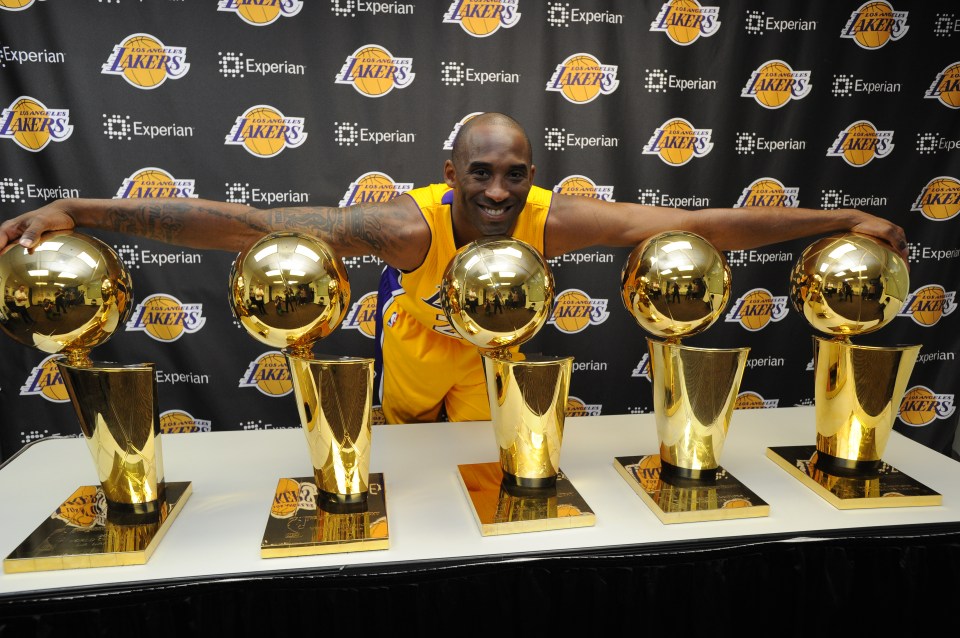  Bryant pictured with his five NBA Championship trophies at staples Center