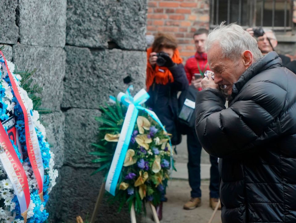  A Holocaust survivor cries as he pays his respect at the death wall at the memorial site of the former German Nazi death camp Auschwitz during ceremonies to commemorate the 75th anniversary