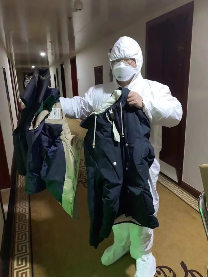  A health worker in a hazmat suit discards clothes worn by someone infected by the killer virus