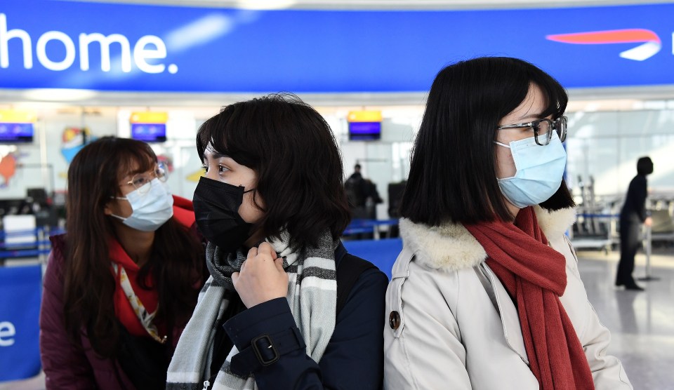  People wearing face masks arrive at Heathrow Airport in London