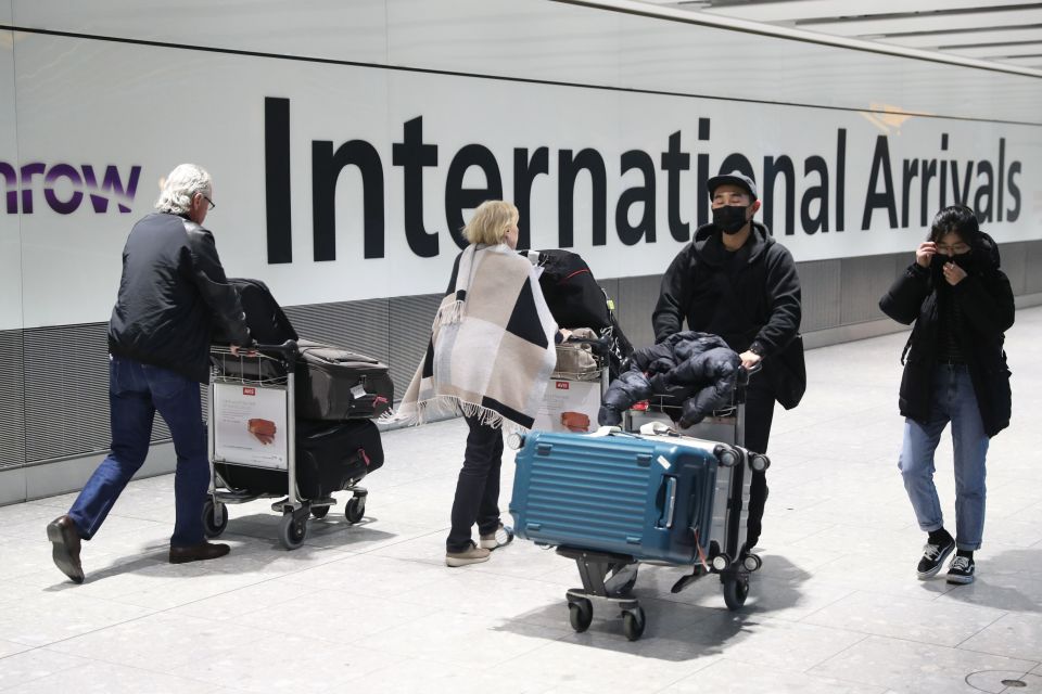  Passengers arrive at Heathrow Airport wearing masks to protect their face