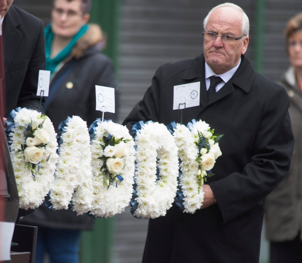  An undertaker carries a poignant floral tribute to the father of four