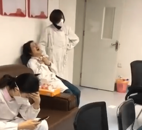  This footage reportedly taken in Wuhan shows a female medic in a white coat clutching her chest and screaming