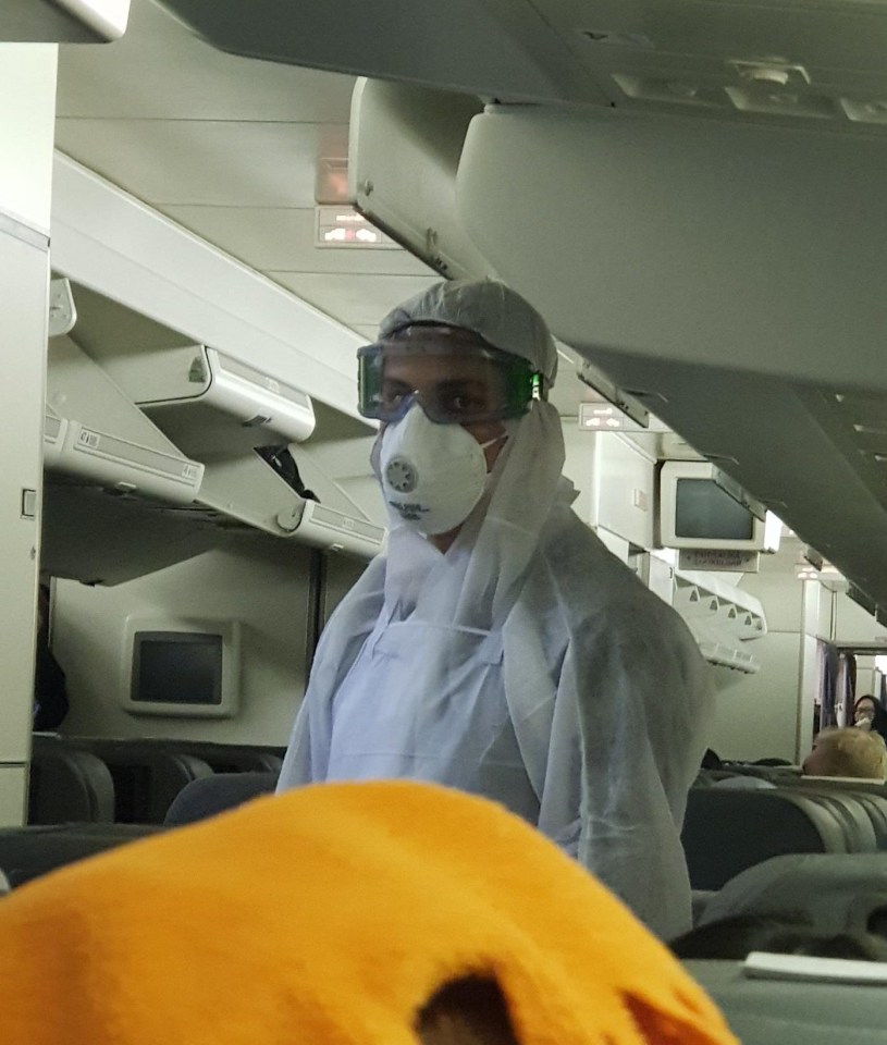 A person in a mask is seen on the flight from Wuhan to UK