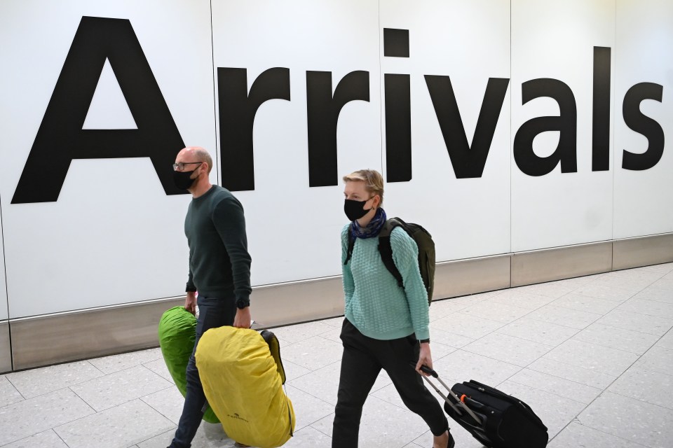 Arrivals at Heathrow Airport wear face masks amid the coronavirus outbreak