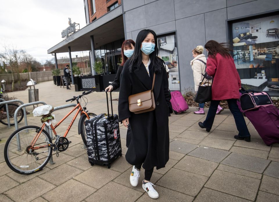  Two women wearing face masks leave the Staycity Hotel in York, where two people were struck down with coronavirus