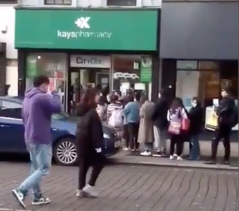 People queuing for face masks at a Liverpool pharmacy amid the panic