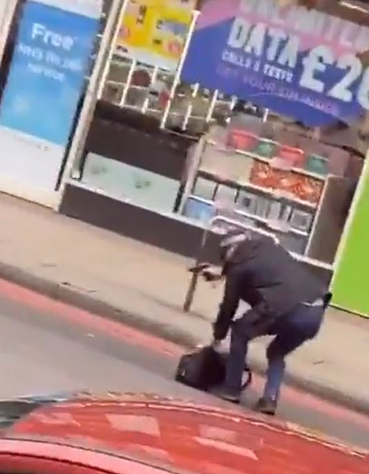  An armed police officer holding a gun as he picked up a bag from the road