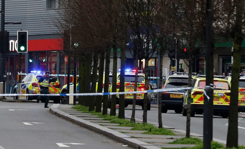  A police officer runs past multiple force cars at the scene