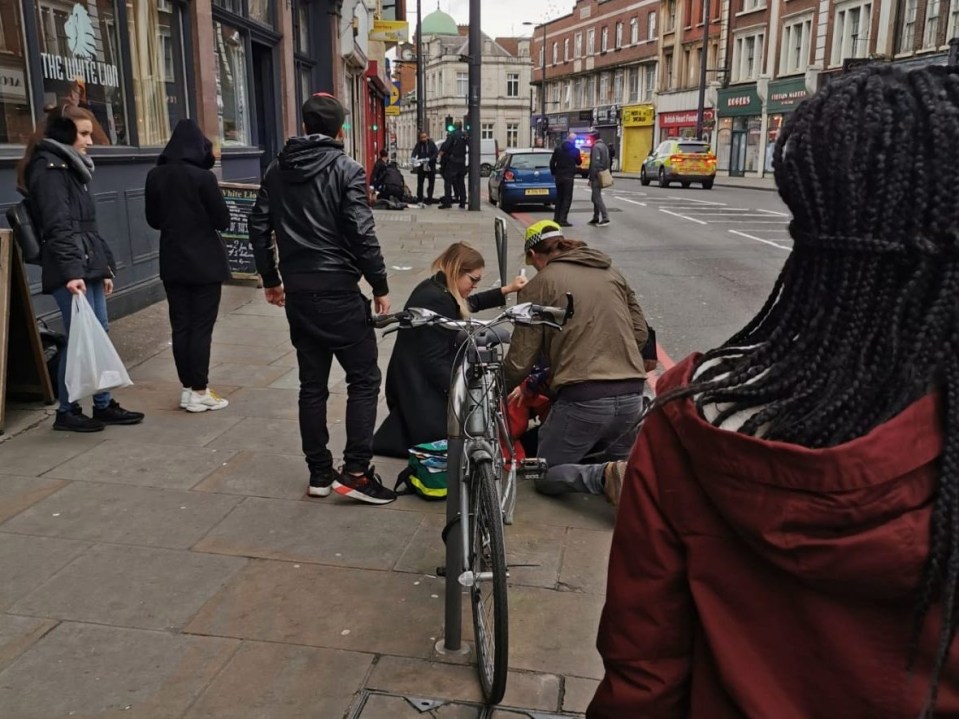 Witnesses help Mrs Luftner  after she was attacked in Streatham