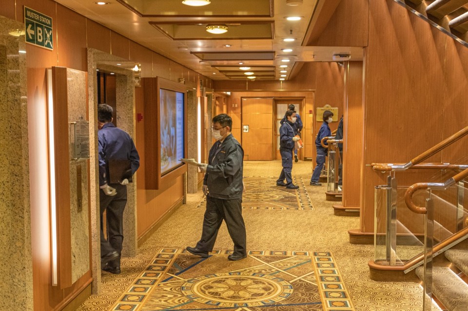  Mask-wearing officials on the quarantined Diamond Princess where ten passengers have tested positive for coronavirus