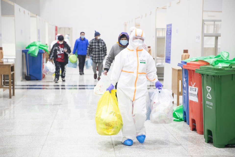  Staff members work in Wuhan International Convention and Exhibition Center as patients infected by the coronavirus arrive for treatment