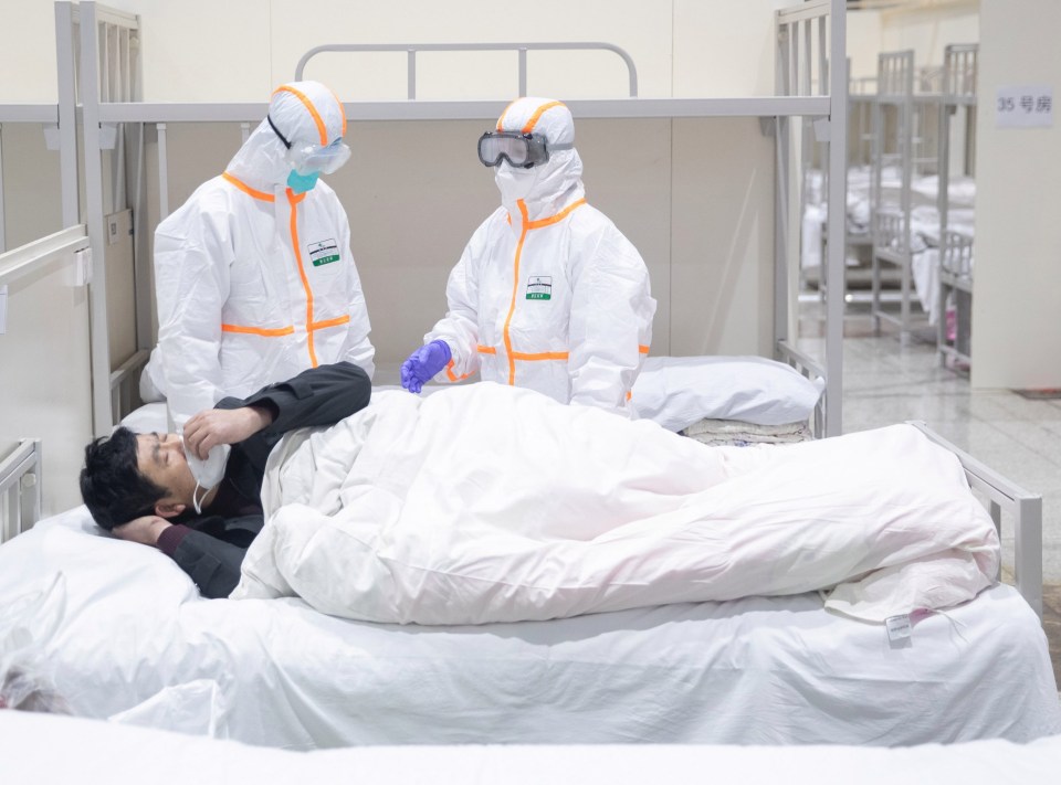 Medical staff attend to a patient infected by the coronavirus at a makeshift hospital in Wuhan where the outbreak started