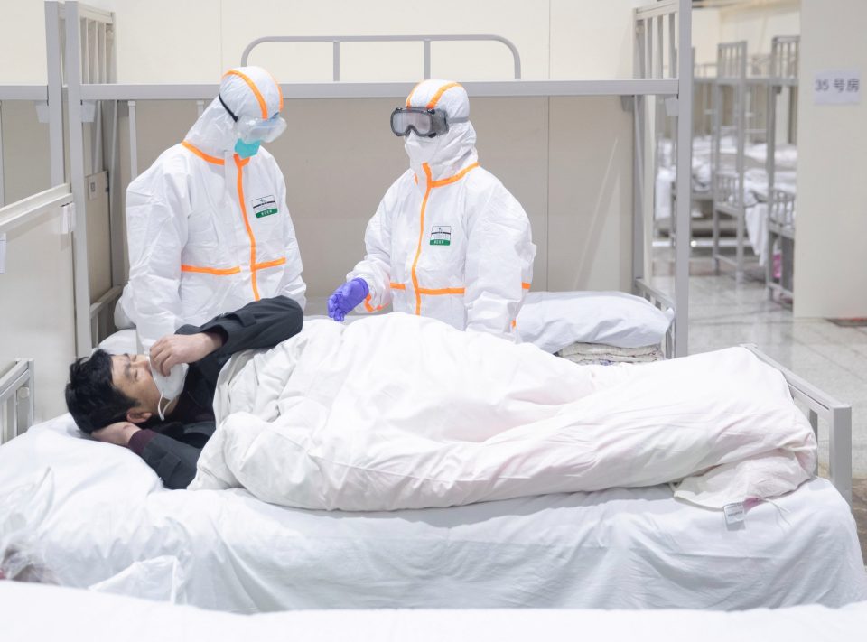  Medical staff attend to a patient infected by the coronavirus at a makeshift hospital in Wuhan where the outbreak started