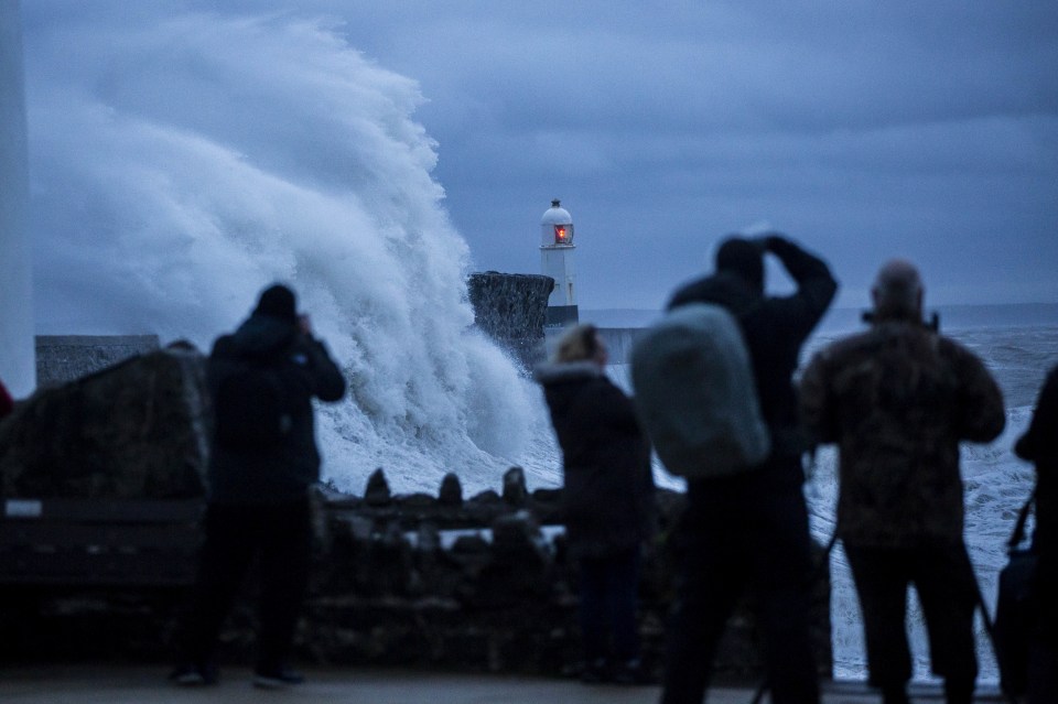 Photographers and storm chasers watch as huge waves crash over Porthcawl Lighthouse