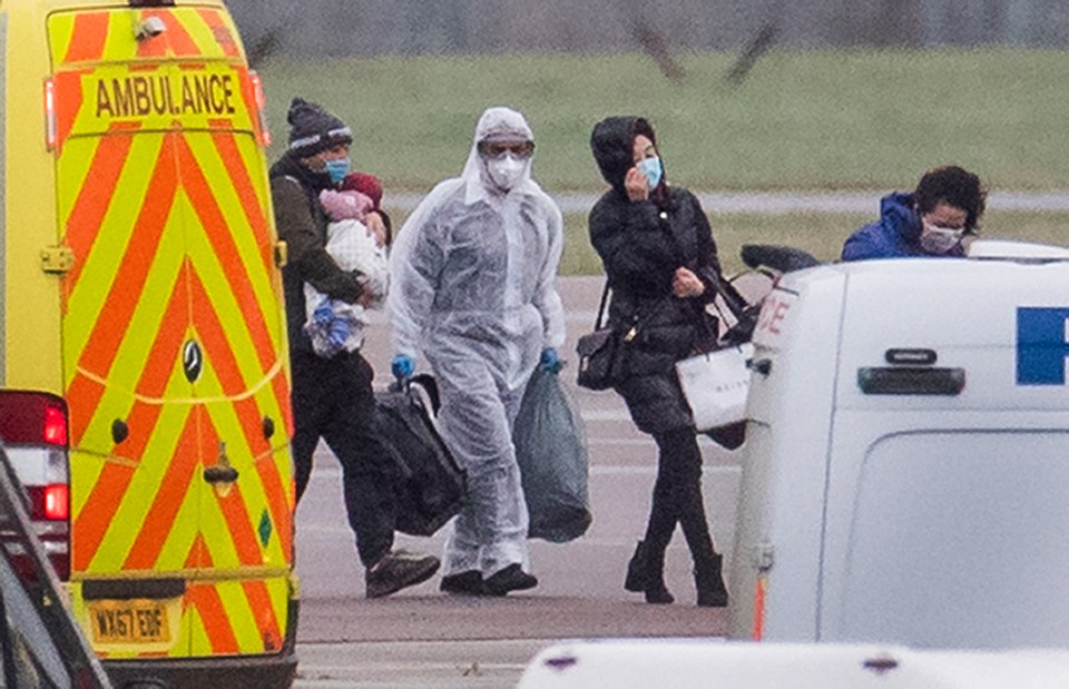 Passengers are seen carrying their belongings as they are taken off the flight