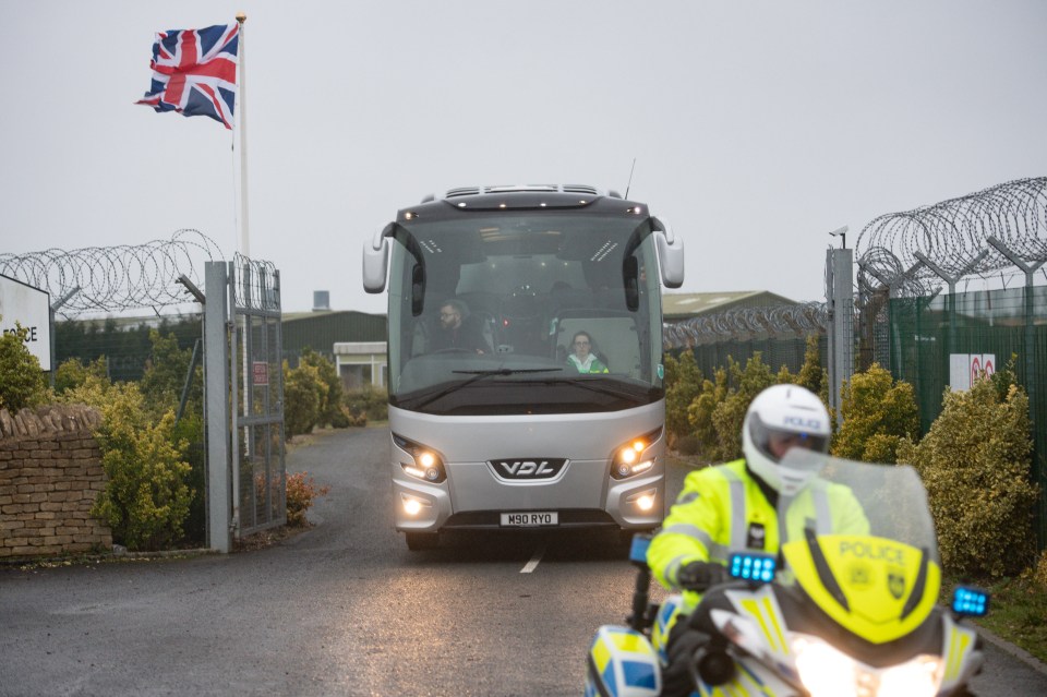 A coach is escorted by police to the quarantine