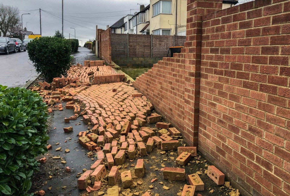 A brick wall crumbles during the storm in South Woodford, London