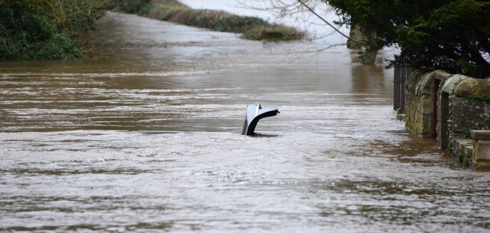 Two vehicles are submerged in flood water on Well Bank in Corbridge, Northumberland