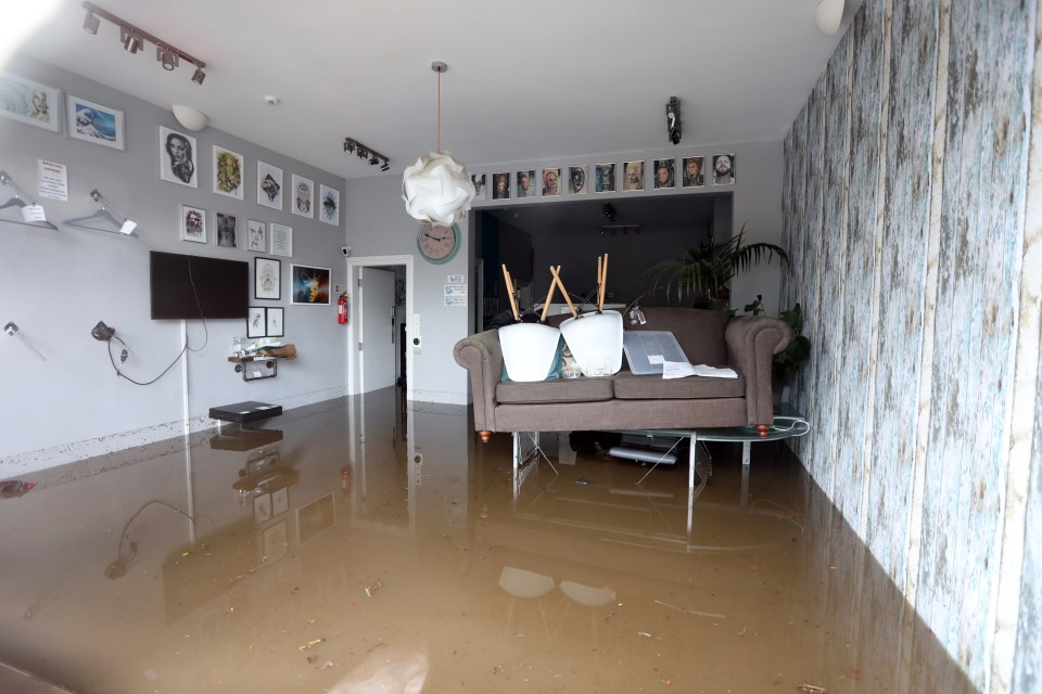  A hairdressers tries to prevent damage to its stock in the centre of Sowerby Bridge