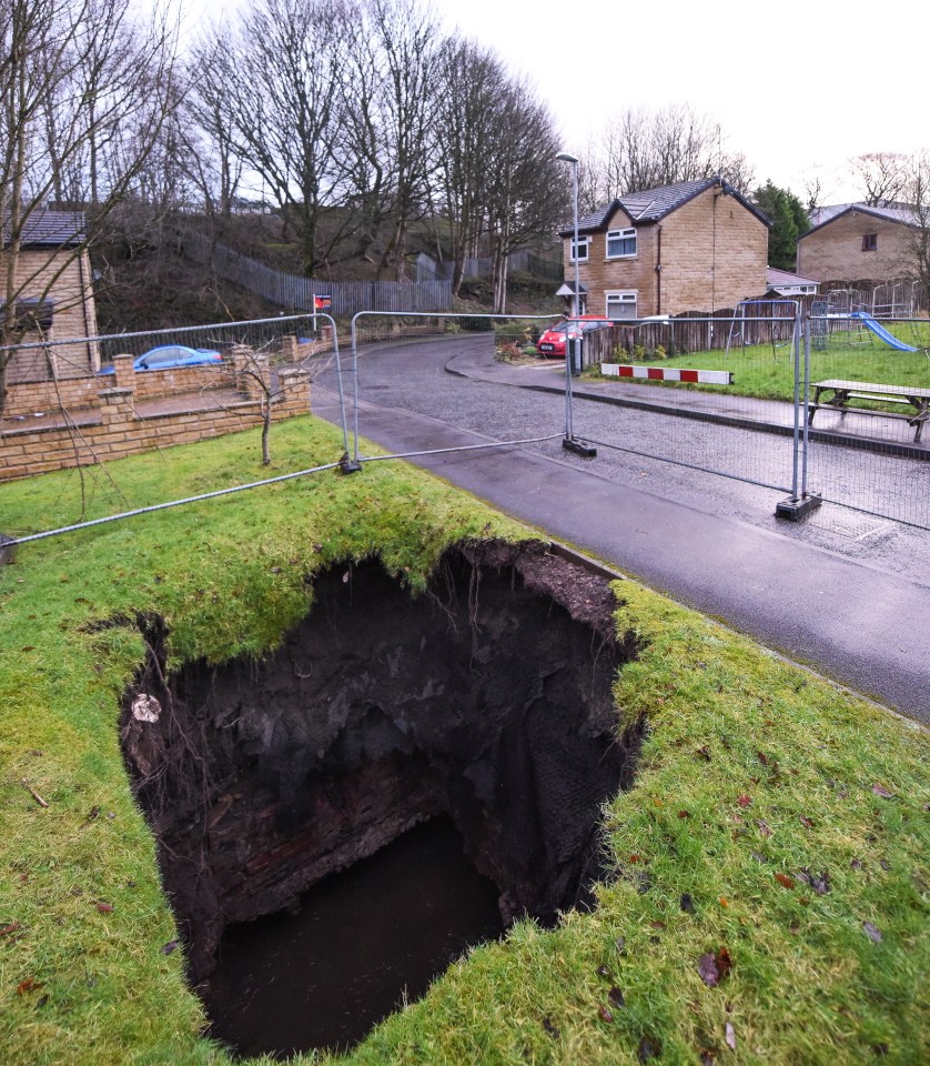  A huge sinkhole is seen this morning, which opened up next to properties in Rochdale, Greater Manchester