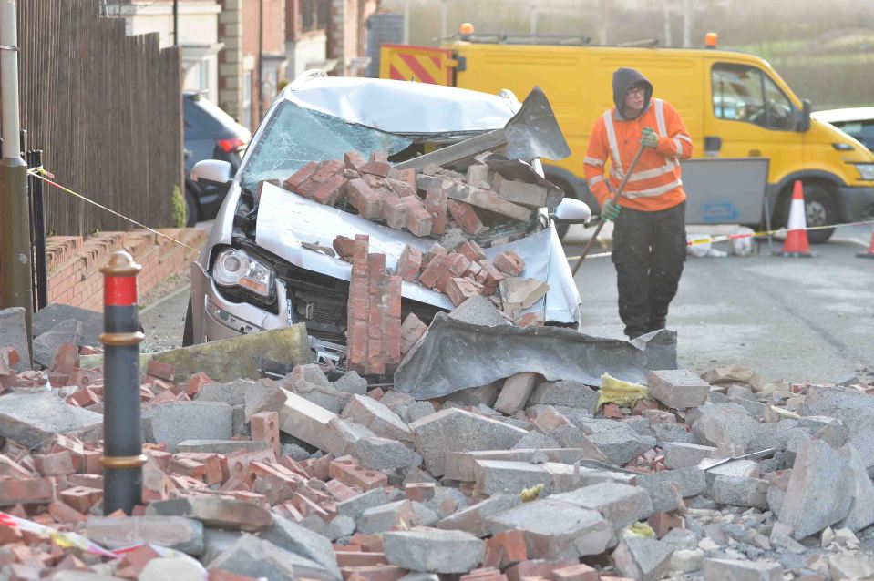  A car wrecked by a collapsed gable wall in Leicester