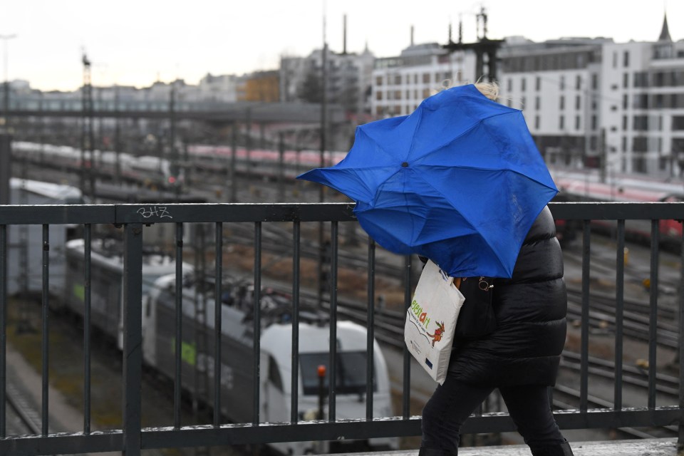  A pedestrian battles high winds in Munich, Germany, where many train services were cancelled