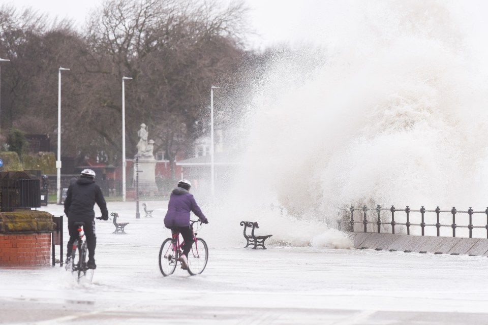  Brave souls take on the waves crashing over the wall of the promenade at Wallasey in Wirral