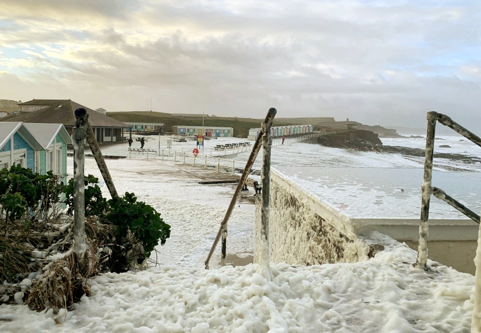  Sea foam hits the shore at Crooklets beach near Bude, North Cornwall