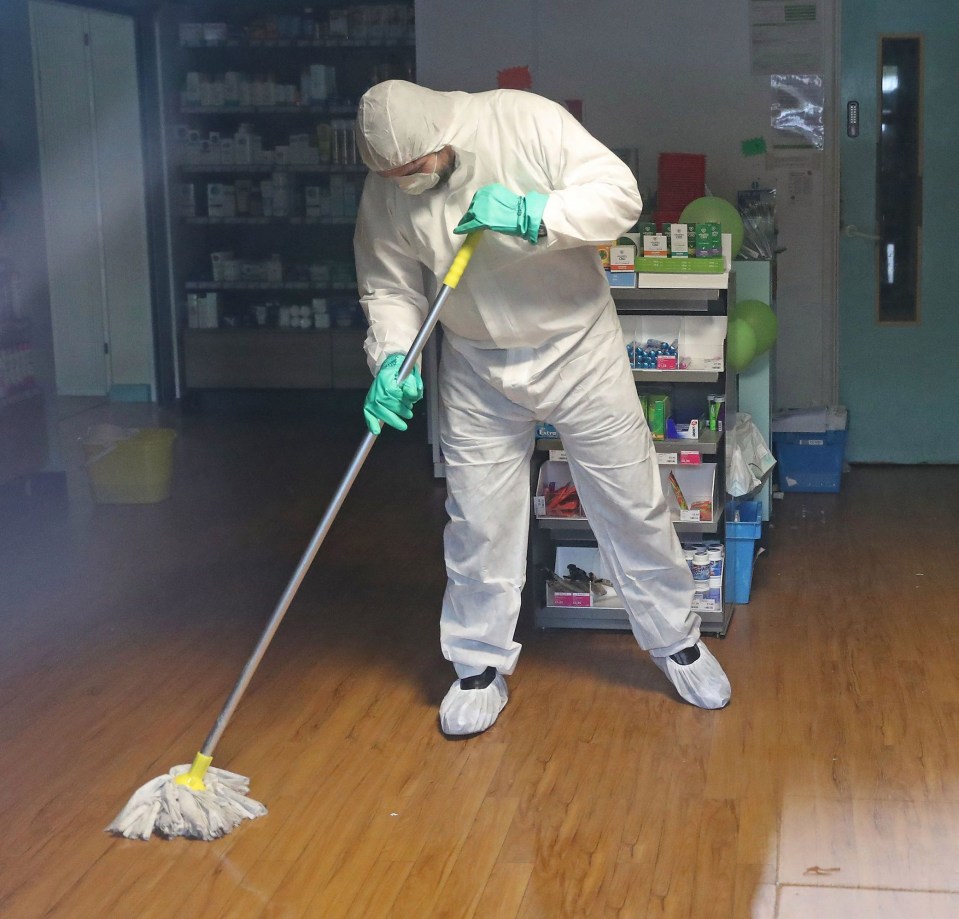 Workers in hazmat suits clean a surgery in Sussex that was closed over the coronavirus crisis