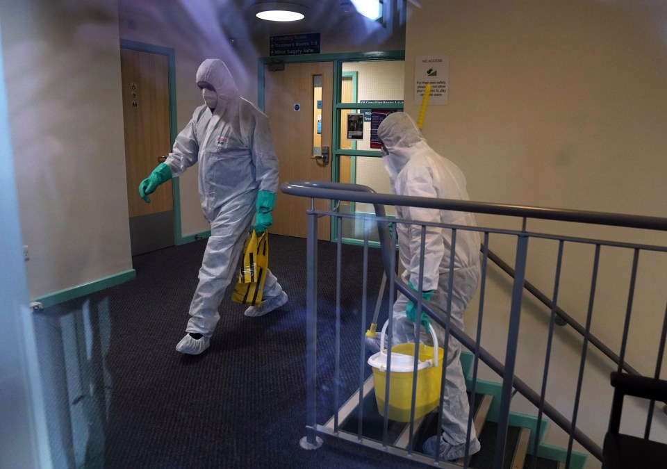 Workers in protective suits inside of the County Oak Medical Centre in Brighton after a GP at the practice was diagnosed with the deadly virus