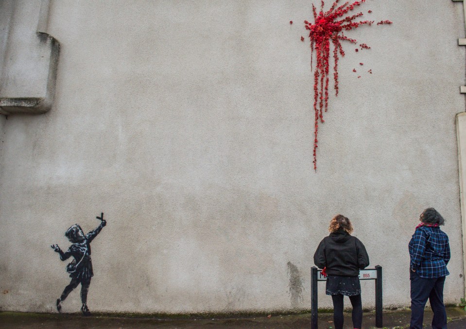  The Banksy piece originally showed a girl with a slingshot catapulting flowers