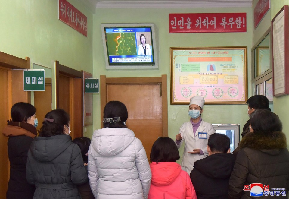  A health worker speaks to people about coronavirus, in Pyongyang