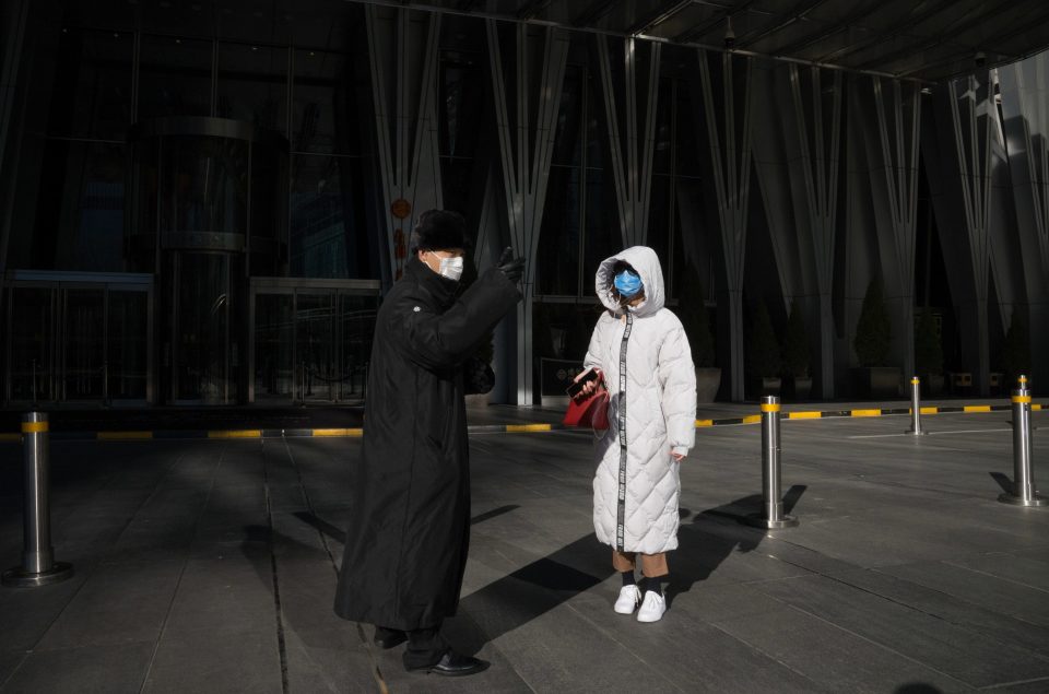  A woman asks a securing guard in front of the entrance of China World Trade Center for direction