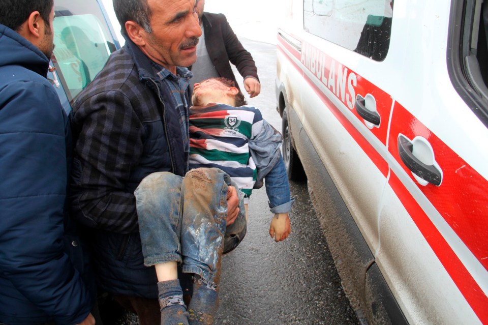  A man carries a wounded boy to an ambulance after an earthquake hit villages in Baskale town in Van province, Turkey