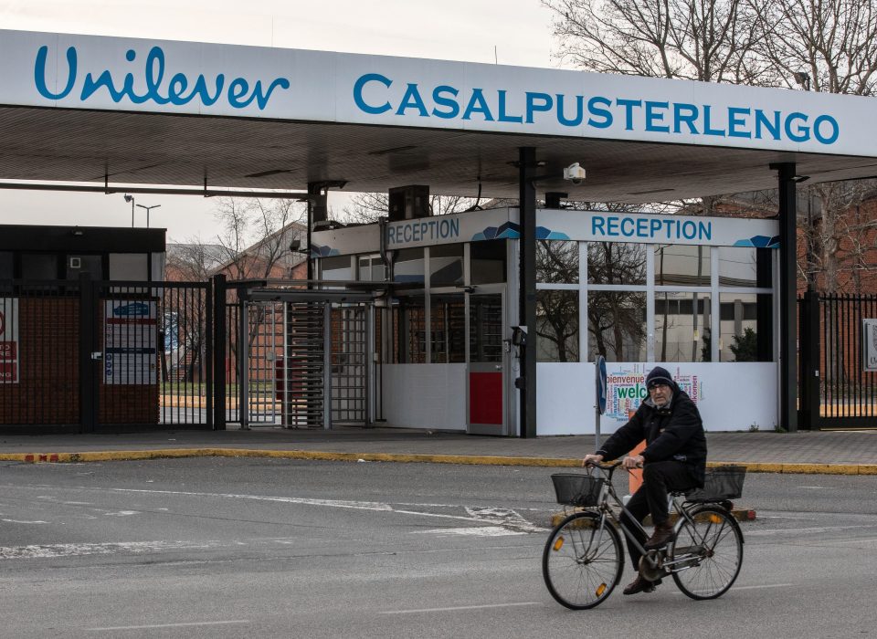  A lone cyclist rides past the closed gates of a Unilever plant near Milan