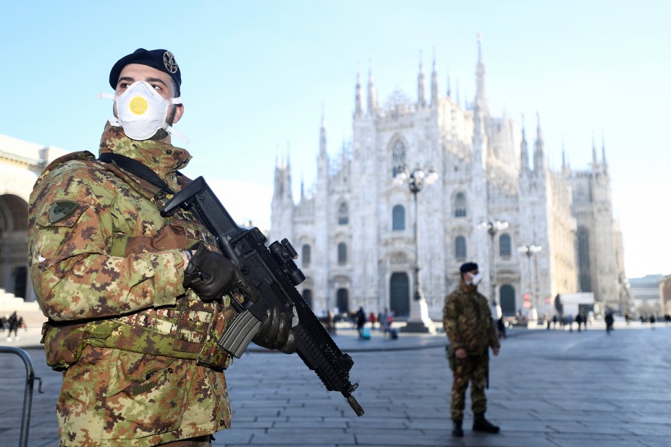  Military officers wearing face masks stand outside Duomo cathedral in Milan