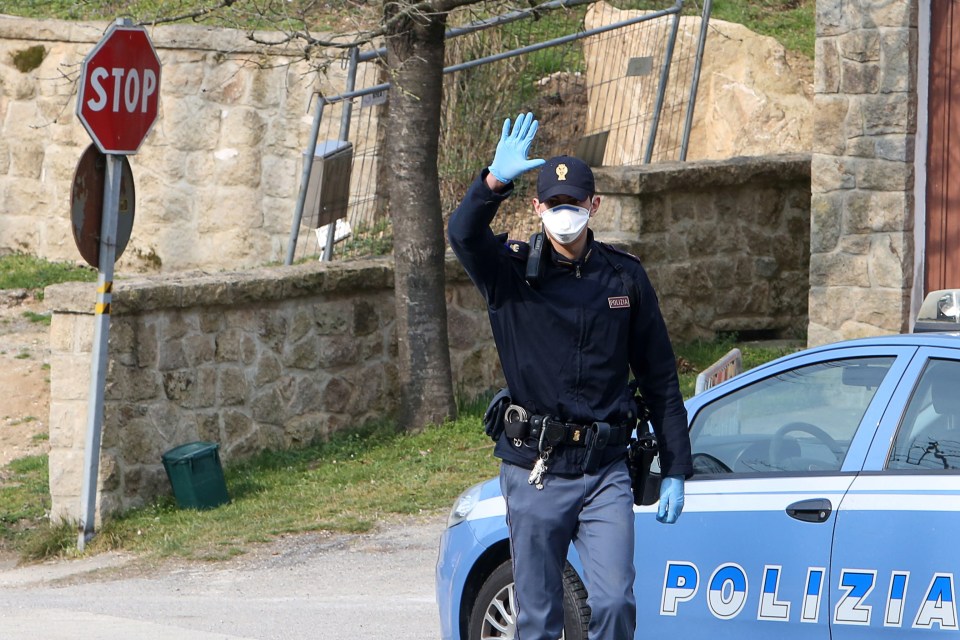  A cop enforces a blockade at the entrance of the small town of Vo' Euganeo, Padova