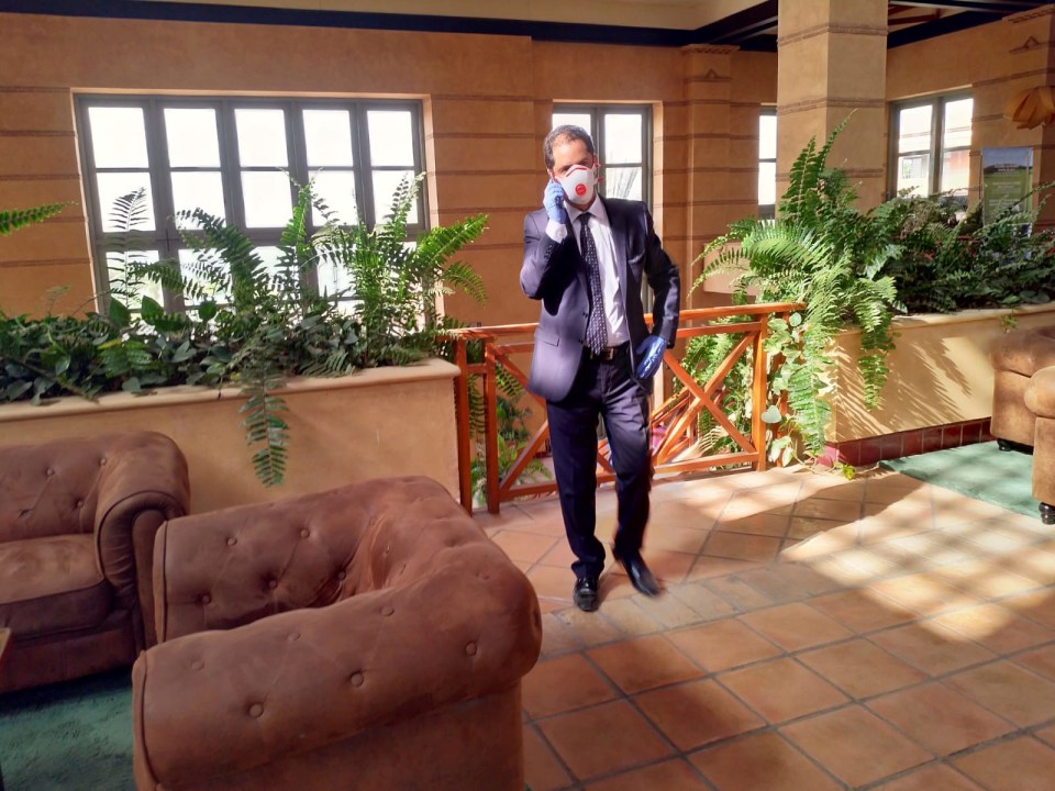 An employee wears a protective mask as he talks on the phone inside the hotel under currently on lockdown