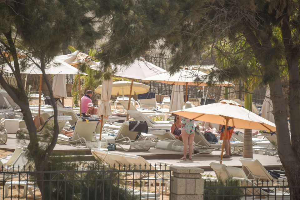  Tourists sunbath at the H10 Costa Adeje Palace Hotel while be held in quarantine