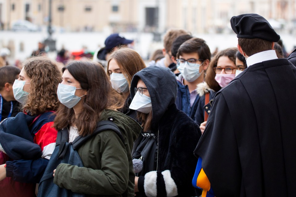  People wear protective masks in St Peter's Square in Vatican City